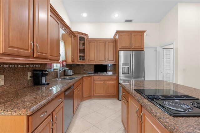 9703 NW 20th St, Coral Springs, FL 33071 - kitchen featuring stainless steel appliances, backsplash, glass insert cabinets, dark stone countertops, and light tile patterned floors
