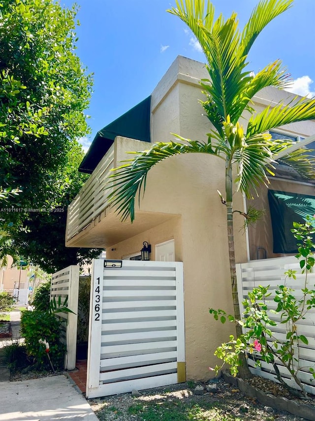 14362 SW 96th Ln, Miami, FL 33186 - view of property exterior with stucco siding and a gate