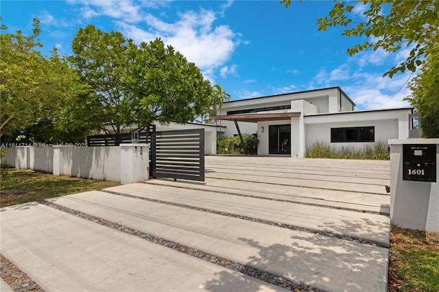 1601 Diplomat Pkwy, Hollywood, FL 33019 - view of front of house with stucco siding, a fenced front yard, and a gate