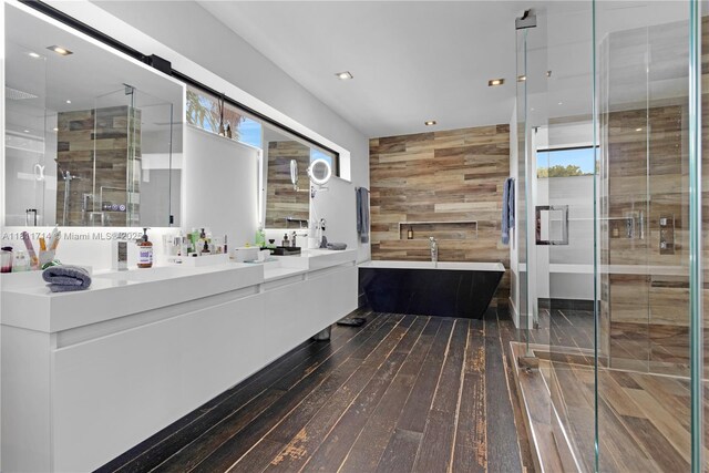 1601 Diplomat Pkwy, Hollywood, FL 33019 - bathroom featuring double vanity, wood-type flooring, a freestanding tub, wood walls, and a shower stall