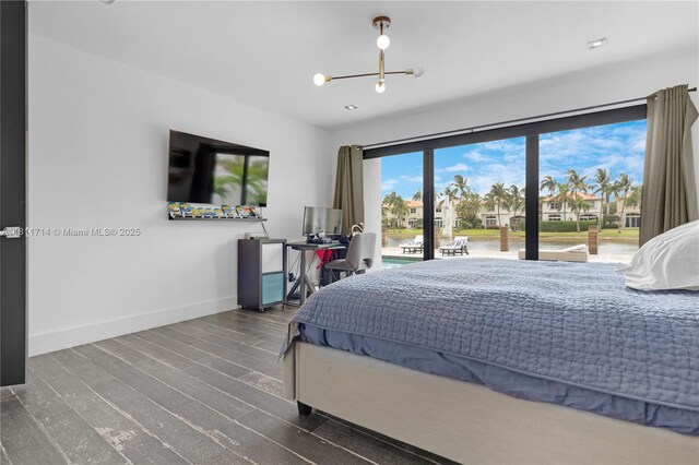 1601 Diplomat Pkwy, Hollywood, FL 33019 - bedroom with access to exterior, baseboards, wood finished floors, an office area, and a chandelier