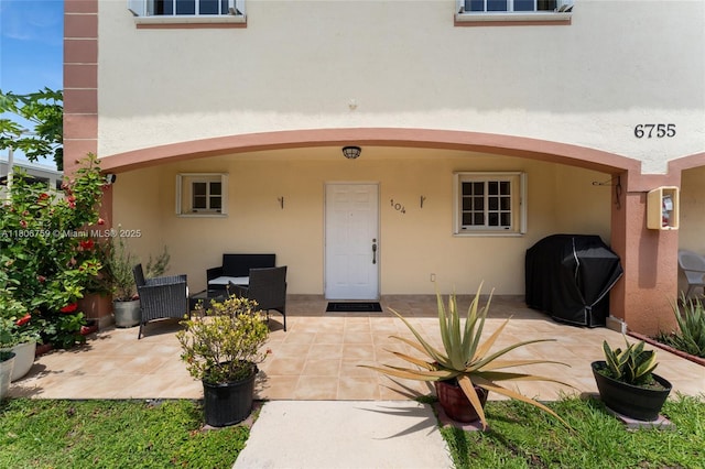 6755 NW 182nd St Unit 104, Hialeah, FL 33015 - view of exterior entry featuring stucco siding and a patio area