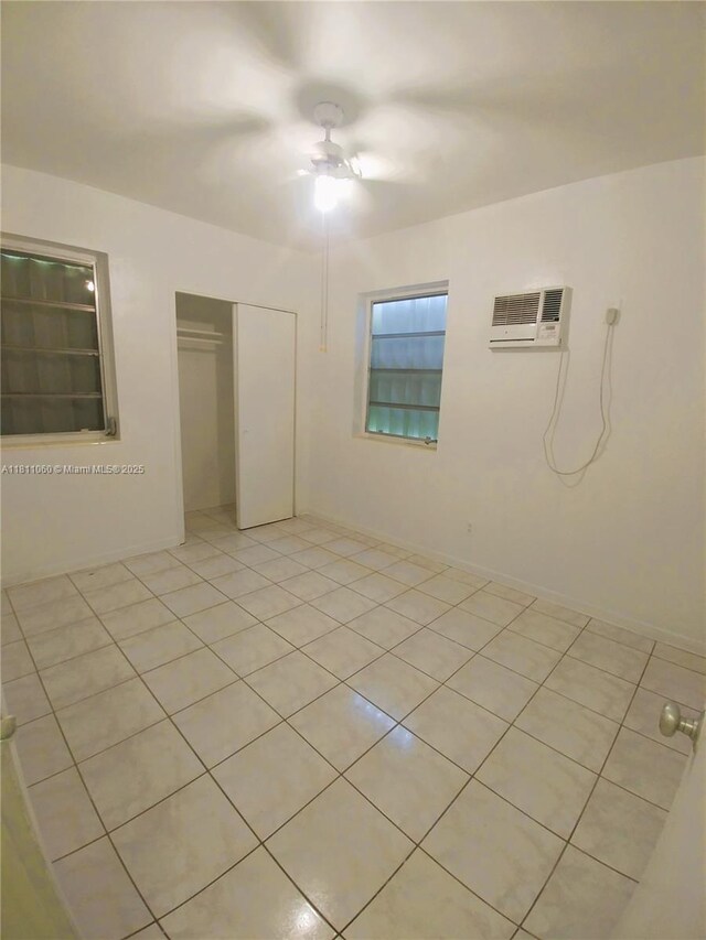 580 NE 139th St, North Miami, FL 33161 - unfurnished bedroom featuring an AC wall unit, light tile patterned floors, a closet, and a ceiling fan