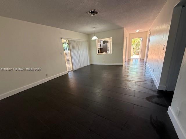 9423 NW 65th St Unit E2, Tamarac, FL 33321 - unfurnished room with dark wood-style floors, baseboards, and a textured ceiling