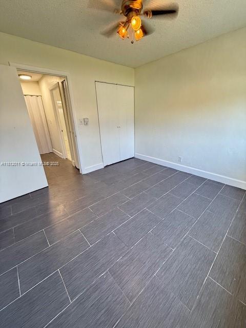 9423 NW 65th St Unit E2, Tamarac, FL 33321 - unfurnished bedroom with baseboards, ceiling fan, and a closet