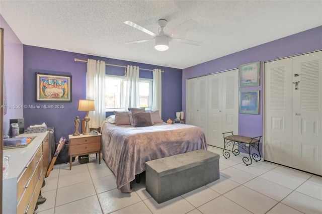 13097 Via Minerva, Delray Beach, FL 33484 - bedroom featuring light tile patterned floors, a ceiling fan, a textured ceiling, and two closets