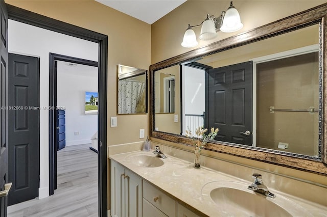 16880 SW 49th Ct, Miramar, FL 33027 - bathroom featuring double vanity, wood finished floors, and baseboards
