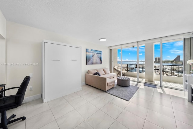 555 NE 15th St Unit 516, Miami, FL 33132 - living room with a water view, a wall of windows, a desk, a textured ceiling, and baseboards