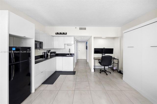 555 NE 15th St Unit 516, Miami, FL 33132 - kitchen with black appliances, white cabinetry, dark countertops, an office area, and light tile patterned floors
