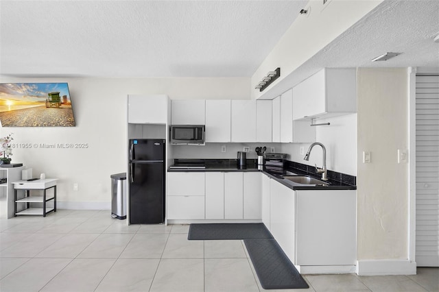 555 NE 15th St Unit 516, Miami, FL 33132 - kitchen with freestanding refrigerator, stainless steel microwave, a sink, a textured ceiling, and dark countertops