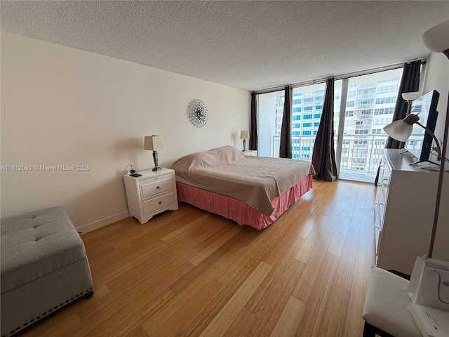 18051 Biscayne Blvd Unit 1505, Aventura, FL 33160 - bedroom with access to exterior, light wood finished floors, a textured ceiling, a wall of windows, and baseboards
