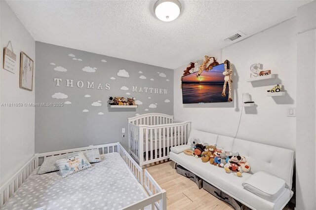 5651 SW 139th Pl, Miami, FL 33183 - bedroom with wood finished floors, a textured ceiling, and a crib