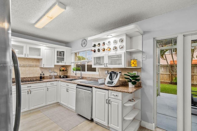 7251 SW 158th Pl, Miami, FL 33193 - kitchen with stainless steel dishwasher, open shelves, a textured ceiling, and decorative backsplash
