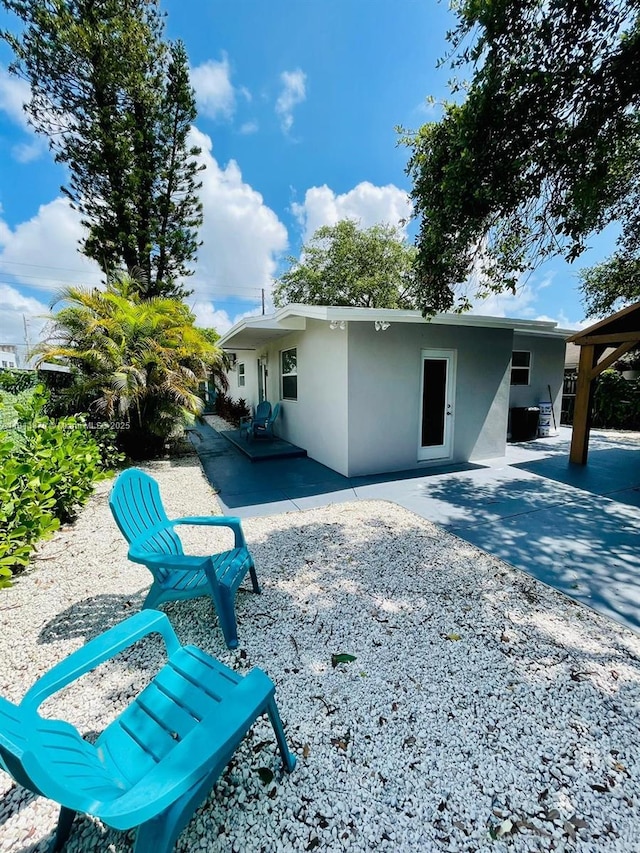 5091 NW 2nd Ave, Miami, FL 33127 - rear view of house with stucco siding and a patio
