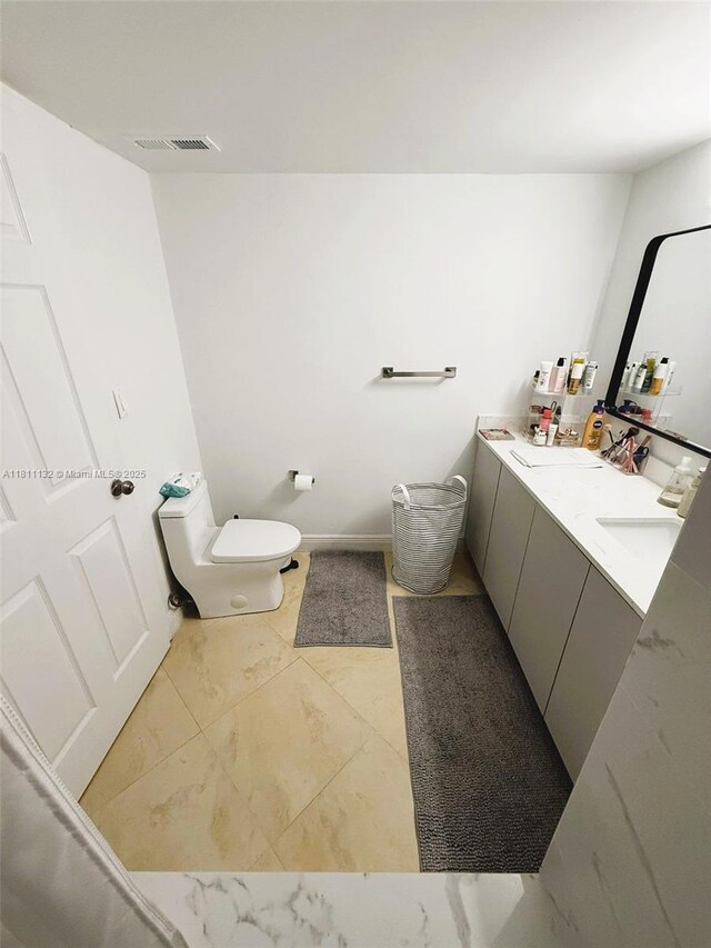4730 NW 97th Ct Unit 76, Doral, FL 33178 - bathroom featuring toilet, double vanity, and marble look tiles