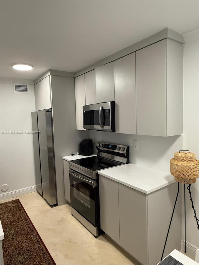 4730 NW 97th Ct Unit 76, Doral, FL 33178 - kitchen with stainless steel appliances, light countertops, gray cabinets, and baseboards