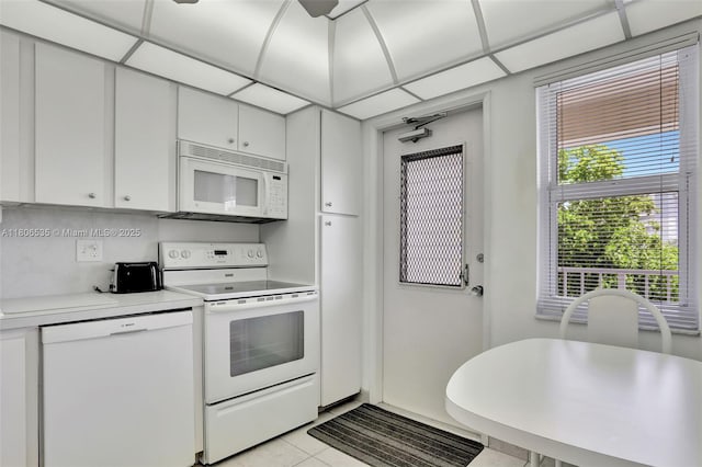 3091 N Course Dr Unit 502, Pompano Beach, FL 33069 - kitchen with white appliances, light countertops, light tile patterned floors, and white cabinetry