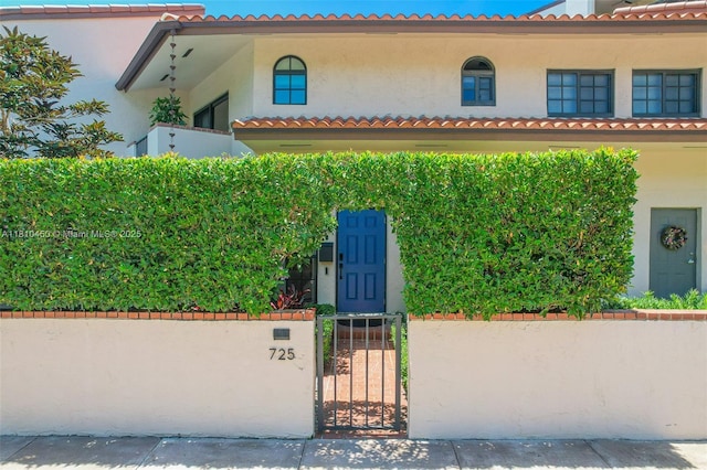 725 Biltmore Ct, Coral Gables, FL 33134 - mediterranean / spanish house with stucco siding, a gate, and a fenced front yard