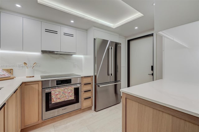 725 Biltmore Ct, Coral Gables, FL 33134 - kitchen featuring stainless steel appliances, light countertops, under cabinet range hood, recessed lighting, and white cabinetry