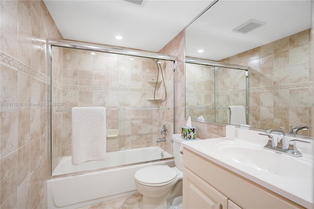 401 Golden Isles Dr Unit 302, Hallandale Beach, FL 33009 - bathroom featuring tile walls, toilet, vanity, enclosed tub / shower combo, and recessed lighting