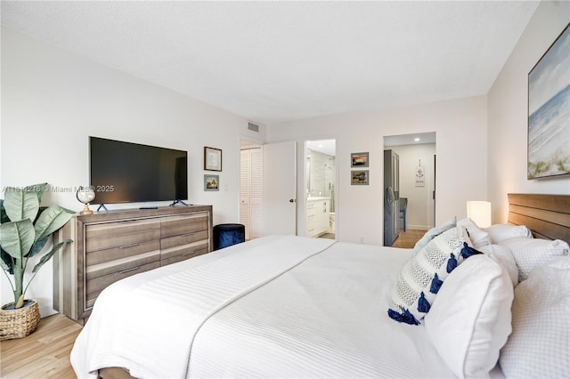 401 Golden Isles Dr Unit 302, Hallandale Beach, FL 33009 - bedroom featuring wood finished floors and ensuite bathroom