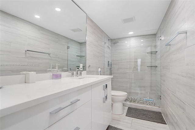 401 Golden Isles Dr Unit 302, Hallandale Beach, FL 33009 - full bath featuring a shower stall, vanity, tile walls, toilet, and recessed lighting