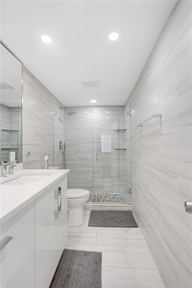 401 Golden Isles Dr Unit 302, Hallandale Beach, FL 33009 - full bath featuring tile walls, vanity, a shower stall, toilet, and recessed lighting