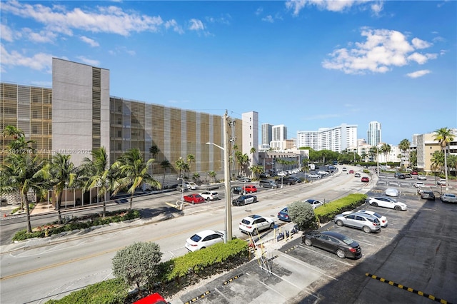 401 Golden Isles Dr Unit 302, Hallandale Beach, FL 33009 - view of asphalt road featuring a city view, street lighting, sidewalks, and curbs