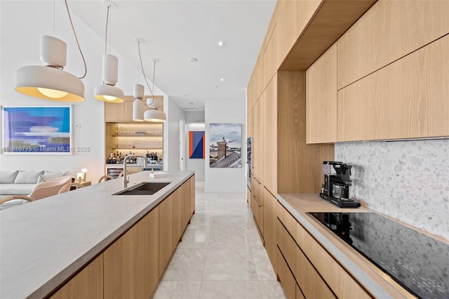 725 NE 22nd St Unit Ph3C, Miami, FL 33137 - kitchen with black electric cooktop, modern cabinets, a sink, decorative backsplash, and light brown cabinets