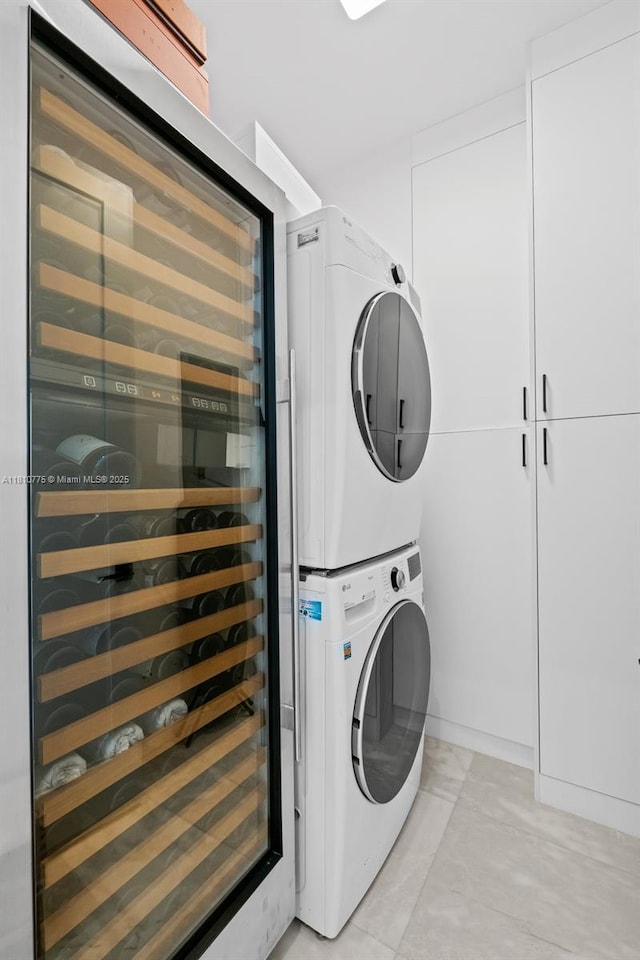 725 NE 22nd St Unit Ph3C, Miami, FL 33137 - washroom featuring stacked washer / dryer, wine cooler, and cabinet space