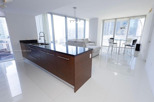 475 Brickell Ave Unit 1715, Miami, FL 33131 - kitchen featuring a sink, modern cabinets, light tile patterned floors, dark brown cabinetry, and dark countertops