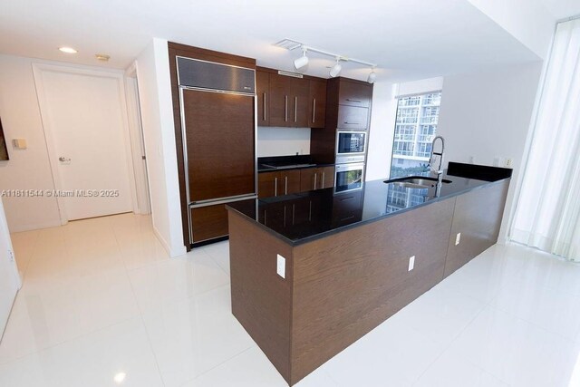 475 Brickell Ave Unit 1715, Miami, FL 33131 - kitchen featuring paneled built in fridge, a sink, dark brown cabinets, rail lighting, and a peninsula