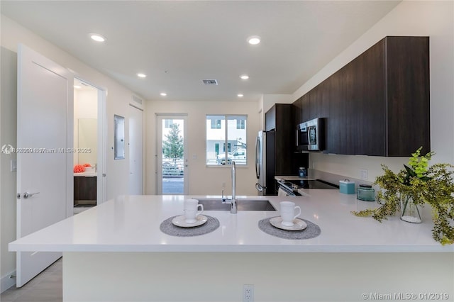 10226 NW 64th Ter Unit 104, Doral, FL 33178 - kitchen featuring light countertops, stainless steel appliances, a peninsula, dark brown cabinets, and recessed lighting