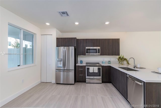 10226 NW 64th Ter Unit 104, Doral, FL 33178 - kitchen featuring stainless steel appliances, a sink, light countertops, dark brown cabinetry, and recessed lighting