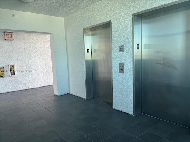 14951 Royal Oaks Ln Unit 1804, North Miami, FL 33181 - corridor featuring elevator, a textured wall, a textured ceiling, and dark tile patterned floors