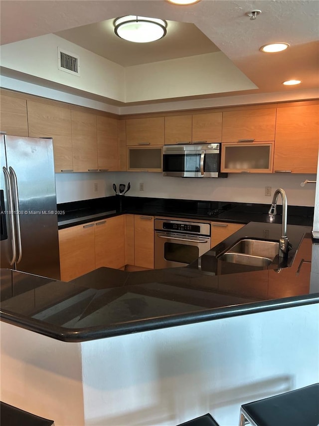 14951 Royal Oaks Ln Unit 1804, North Miami, FL 33181 - kitchen featuring stainless steel appliances, dark countertops, recessed lighting, light brown cabinets, and a peninsula