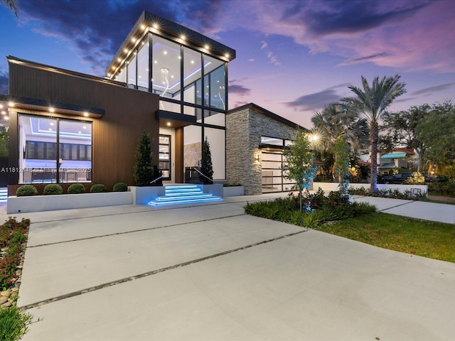 401 Bontona Ave, Fort Lauderdale, FL 33301 - modern home featuring driveway, stone siding, a balcony, and a garage