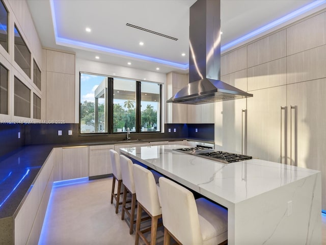 401 Bontona Ave, Fort Lauderdale, FL 33301 - kitchen with modern cabinets, island range hood, light stone countertops, decorative backsplash, and recessed lighting
