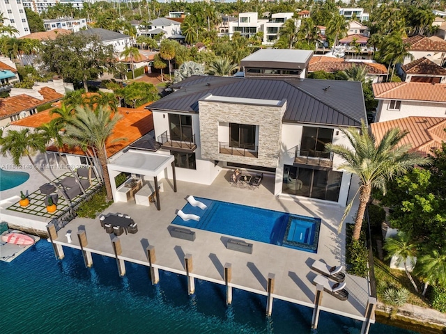 401 Bontona Ave, Fort Lauderdale, FL 33301 - back of property with a balcony, stucco siding, stone siding, a standing seam roof, and metal roof