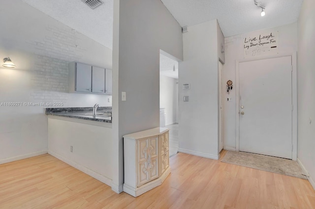 10 Afton Pl, Boynton Beach, FL 33426 - foyer entrance with light wood-type flooring, baseboards, a textured ceiling, and high vaulted ceiling