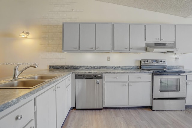 10 Afton Pl, Boynton Beach, FL 33426 - kitchen featuring appliances with stainless steel finishes, a sink, under cabinet range hood, vaulted ceiling, and white cabinetry