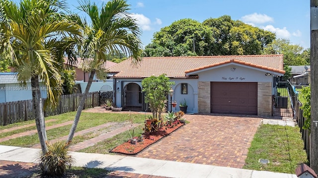 5808 Polk St, Hollywood, FL 33021 - mediterranean / spanish house with a tile roof, decorative driveway, stucco siding, an attached garage, and a gate