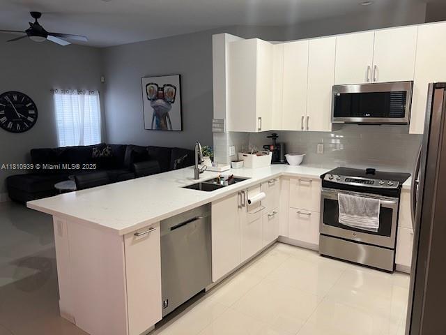 1020 Silktree Ln, Weston, FL 33327 - kitchen with appliances with stainless steel finishes, a sink, a ceiling fan, a peninsula, and light countertops