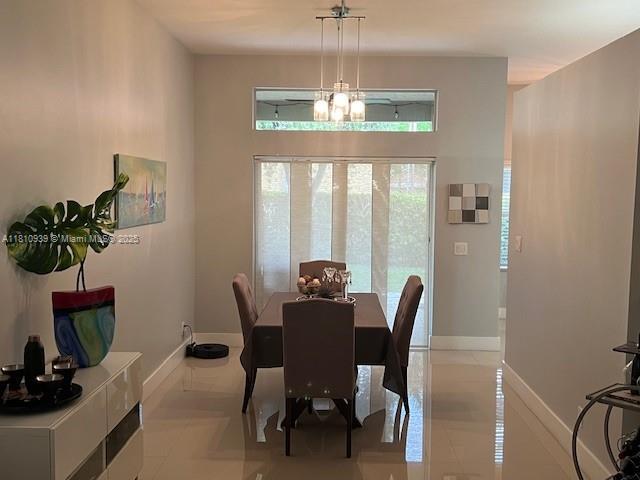 1020 Silktree Ln, Weston, FL 33327 - dining area with baseboards, a chandelier, and light tile patterned floors