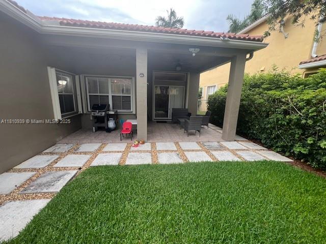 1020 Silktree Ln, Weston, FL 33327 - back of house featuring a patio, a yard, stucco siding, and a tile roof