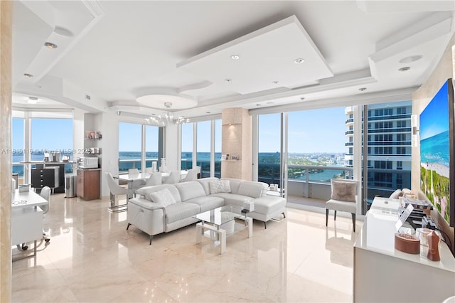 4775 Collins Ave Unit Ph4107, Miami Beach, FL 33140 - living area featuring a water view, floor to ceiling windows, a chandelier, and a tray ceiling