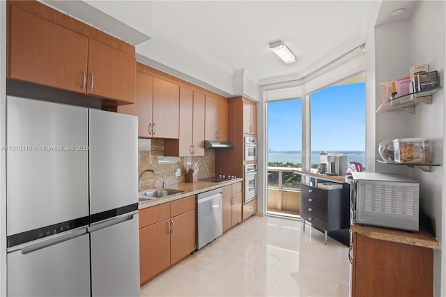 4775 Collins Ave Unit Ph4107, Miami Beach, FL 33140 - kitchen with stainless steel appliances, a sink, under cabinet range hood, decorative backsplash, and a water view