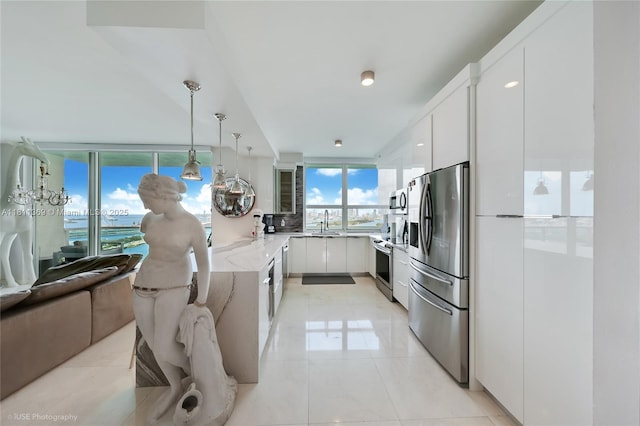 650 W Ave Unit Ph09, Miami Beach, FL 33139 - kitchen with stainless steel appliances, modern cabinets, white cabinetry, pendant lighting, and light tile patterned flooring