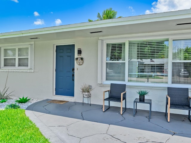 11610 NW 32nd Mnr, Sunrise, FL 33323 - view of exterior entry featuring stucco siding and a patio