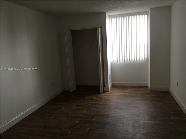 850 N Miami Ave Unit W-2003, Miami, FL 33136 - unfurnished bedroom featuring dark wood finished floors, multiple windows, baseboards, and a textured ceiling